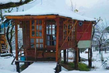 snow and wooden Machaan cottages
